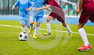 Young soccer players running towards soccer ball. Football soccer game for youth teams