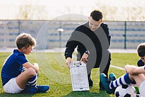 Young Soccer Trainer Coach Explaining Tactic on Team Sports Tactics Board