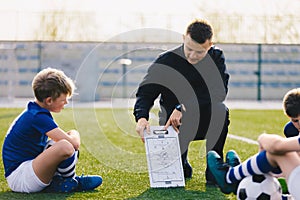 Young Soccer Trainer Coach Explaining Tactic on Team Sports Tactics Board photo