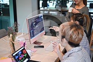 Young software developers team working together for developing website design and coding technologies at creative office photo