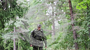 Young soldier with backpack in forest