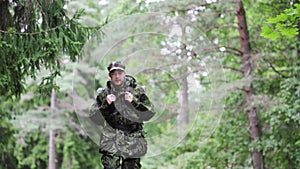 Young soldier with backpack in forest