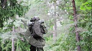 Young soldier with backpack in forest