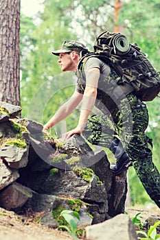 Young soldier with backpack in forest