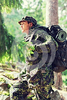 Young soldier with backpack in forest