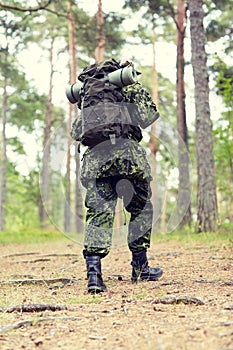 Young soldier with backpack in forest