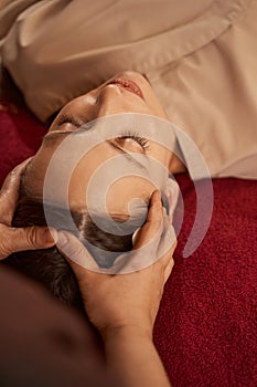 Young spa client having her scalp massaged