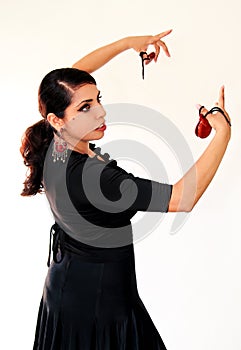 Young Spanish gipsy woman dancing flamenco with brown castanets.