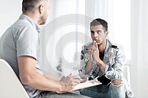 Young spanish man talking with psychologist about future plans