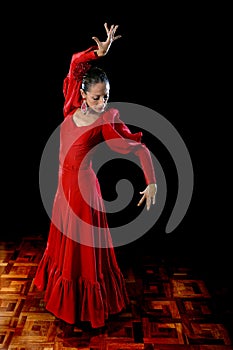 Young Spanish woman dancing flamenco in typical folk red dress