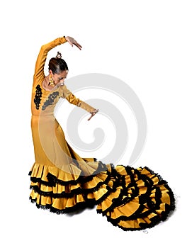 Young Spanish woman dancing flamenco in typical folk tailed gown dress