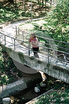 Young Spanish woman leaning on a bridge in a public park