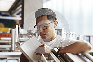 Young man reading book in a book store.