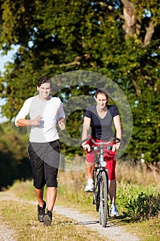 Young sport couple jogging and cycling