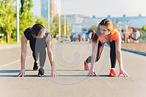 Young sport couple in starting position prepared to compete and run.