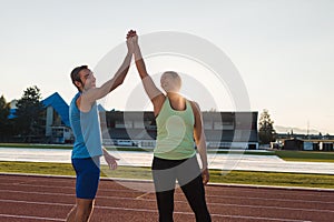 Young sport couple training on athletic stadium