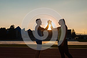 Young sport couple training on athletic stadium