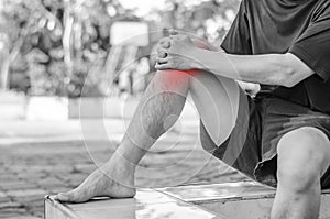 Young sport man with strong athletic legs holding knee