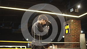 Young sport man warming up at gym. Male boxer doing punches on boxing ring