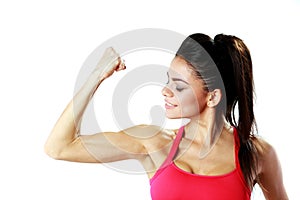 Young sport woman looking at her biceps