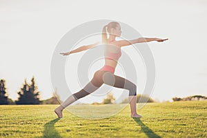 Young sport woman meditates while practicing yoga in a spring mo