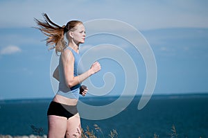 Young sport woman running on sunny day