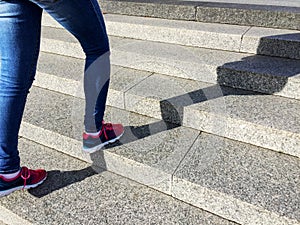 Young sport woman running up on stone stairs with sun spot background. Healthy lifestyle, workout and diet concept