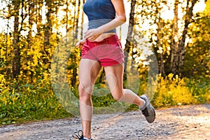 Young sport woman runs on the road
