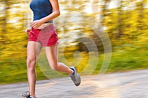 Young sport woman runs on the road