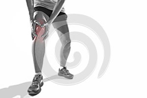 Young sport woman with strong athletic legs holding knee with hands in pain suffering ligament injury