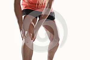 Young sport woman with strong athletic legs holding knee with hands in pain suffering ligament injury