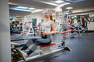 Young sport woman wearing sport wear doing exercise with fitness equipment at gym, she exercise for strong back and