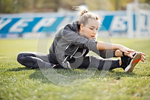 Young sport woman in white stretching in park on the grass