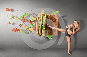 Young sport women boxing a hamburger as unhealthy food