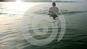 Young sporting man swims in the sea