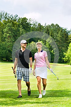 Young sportive couple playing golf on a course