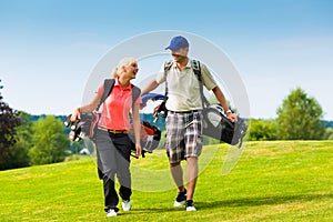 Young sportive couple playing golf on a course