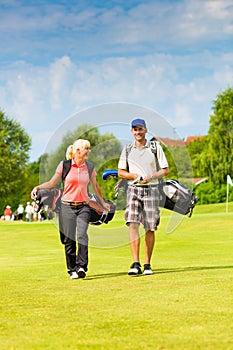 Young sportive couple playing golf on a course