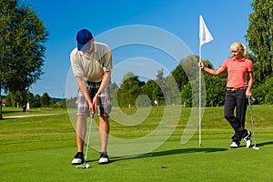 Young sportive couple playing golf on a course