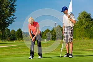 Young sportive couple playing golf on a course