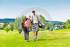 Young sportive couple playing golf on a course photo