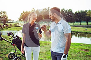 Young sportive couple playing golf on a golf course.