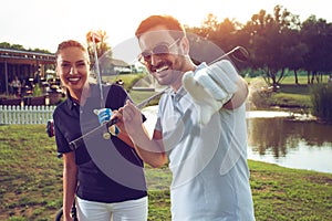 Young sportive couple playing golf on a golf course.