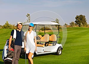 Young sportive couple playing golf on a golf course