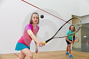 Young sportive couple practicing squash at indoor court