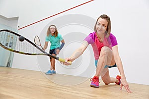 Young sportive couple practicing squash at sport club indoor court