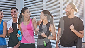 Young sportive people happily talking while going to gym