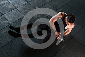 Young sportive strong man in black wear have workout day in gym with ball