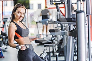 young sportive woman doing exercise with dumbbells