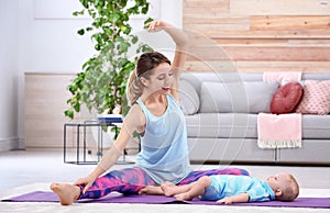 Young sportive woman doing exercise with her son at home.